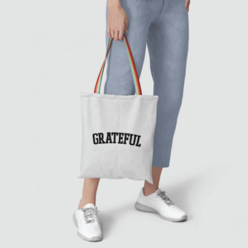 Grateful Tote with rainbow handle on a gray background